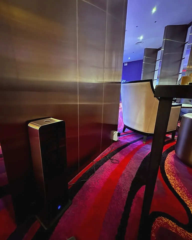 Black tower scent diffuser beside the lounge seating of a luxury cinema