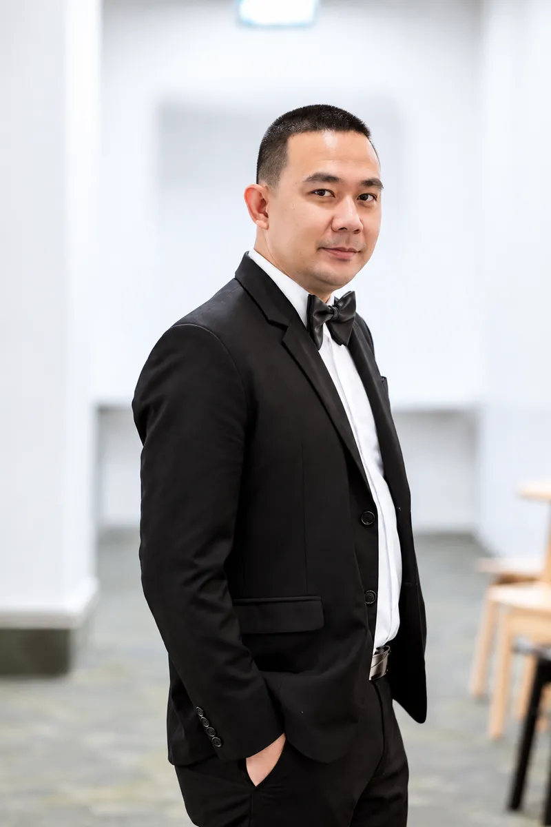 Jansep Ejercito, Founder and CEO of Scent Up Aroma Marketing, in a dark suit and bow tie